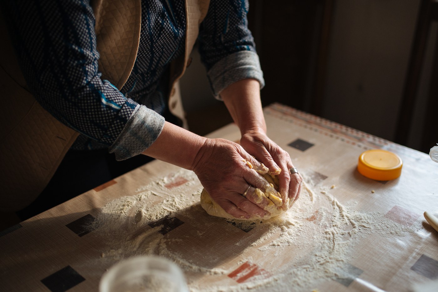 Baker kneading dough on a floured kitchen table