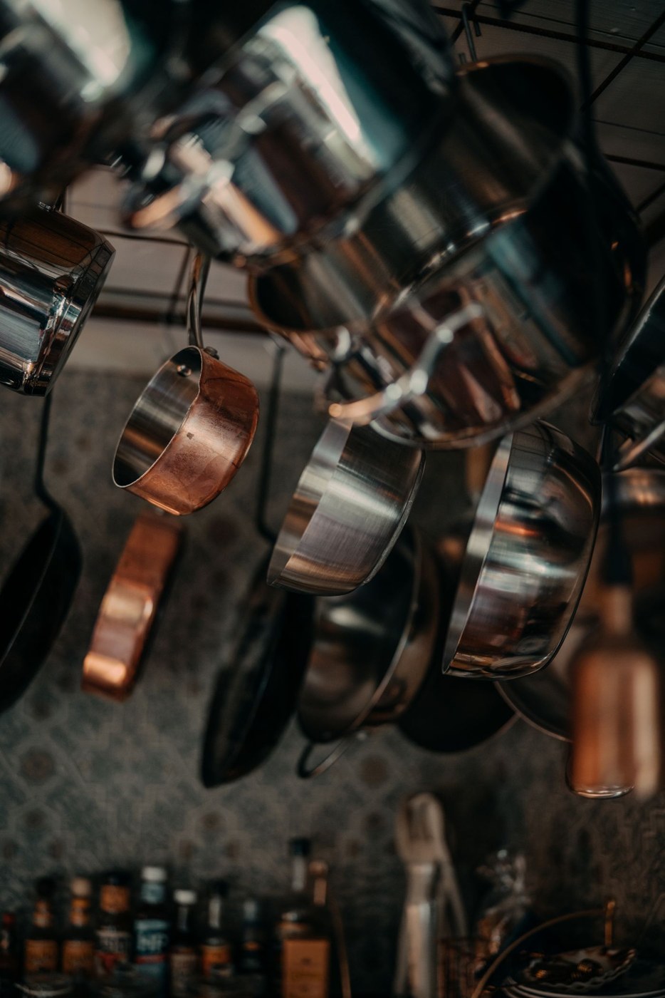 Pots and pans hanging separately above a kitchen workspace